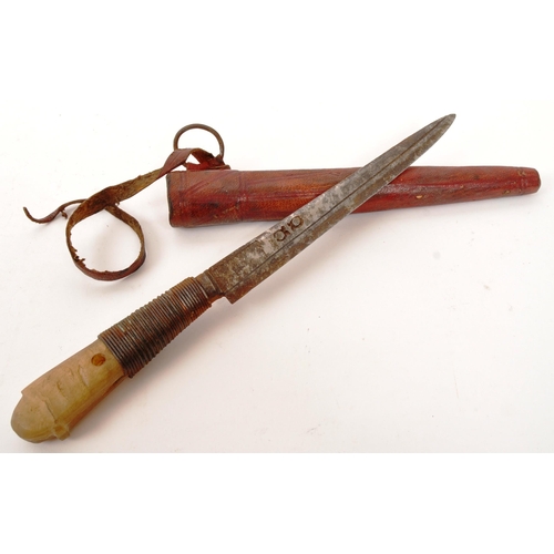 253 - An early 20th Century bone handled knife / letter opener held within red leather sheath. Measuring a... 