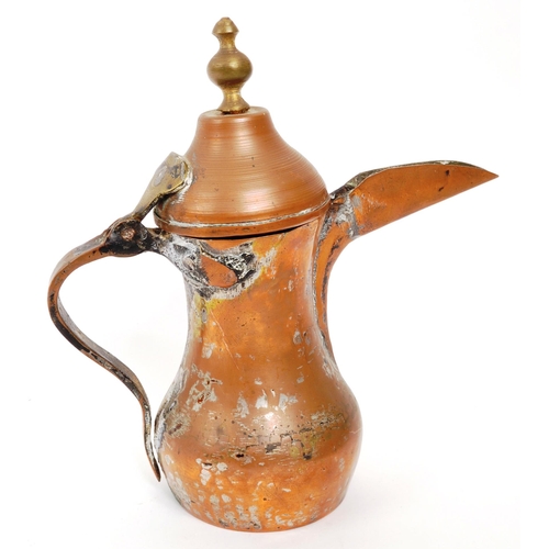 255 - A 19th Century Middle Eastern Arabic brass teapot / coffee pot having hinged weighted lid with round... 