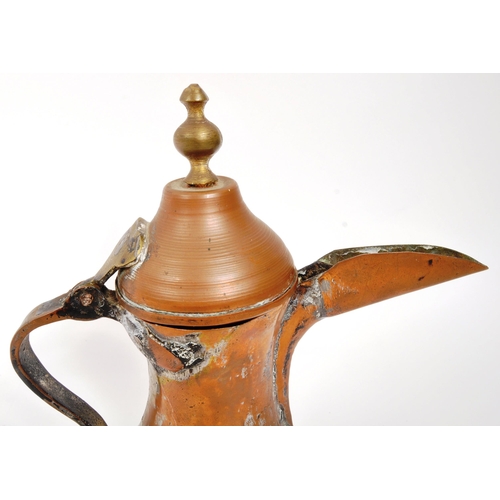 255 - A 19th Century Middle Eastern Arabic brass teapot / coffee pot having hinged weighted lid with round... 