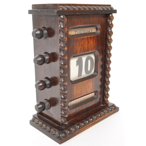 265 - An Edwardian oak perpetual desktop calendar having wrythen twist decoration to each side. Featuring ... 