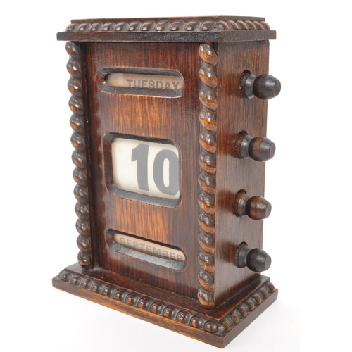 265 - An Edwardian oak perpetual desktop calendar having wrythen twist decoration to each side. Featuring ... 