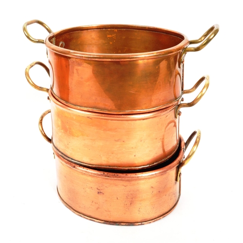 267 - A collection of four 20th Century vintage oval shaped graduating copper pans / planters having bras ... 