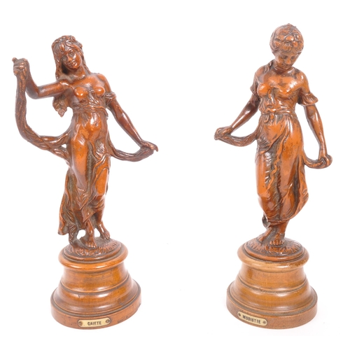 271 - A pair of bronze figurines in the form of ladies with draped clothing raised upon turned circular ba... 