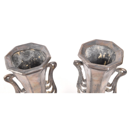 275 - A pair of early 20th Century Art Nouveau pewter German vases raised on four legs. Having rounded squ... 