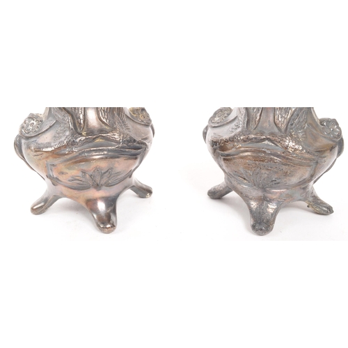 275 - A pair of early 20th Century Art Nouveau pewter German vases raised on four legs. Having rounded squ... 