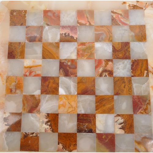 300 - A 20th Century marble circular chess board with central inlaid square board. In cream and red colour... 