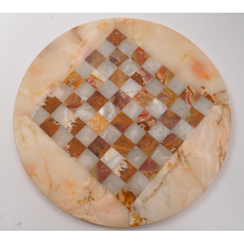 300 - A 20th Century marble circular chess board with central inlaid square board. In cream and red colour... 