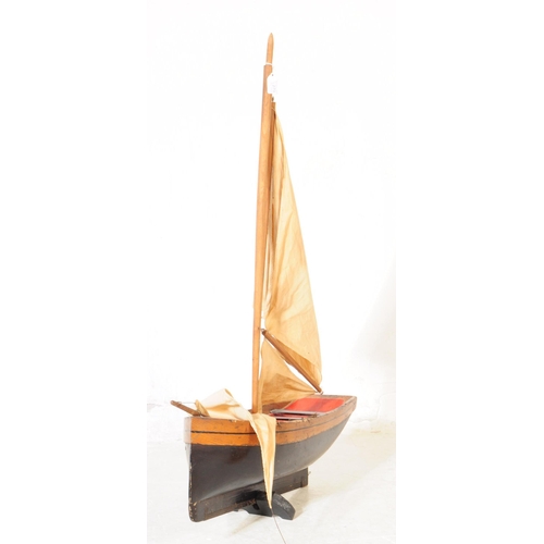 314 - An early 20th Century wood hand grooved and painted model / figure of a ship. Having red interior wi... 