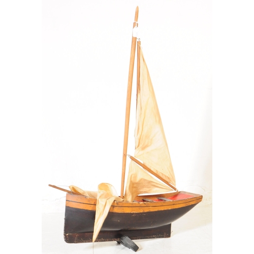 314 - An early 20th Century wood hand grooved and painted model / figure of a ship. Having red interior wi... 