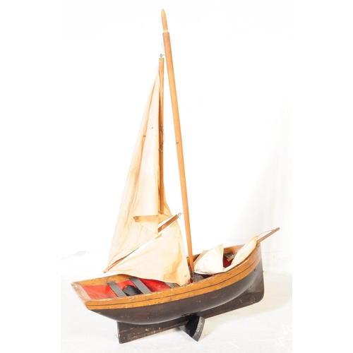 314 - An early 20th Century wood hand grooved and painted model / figure of a ship. Having red interior wi... 