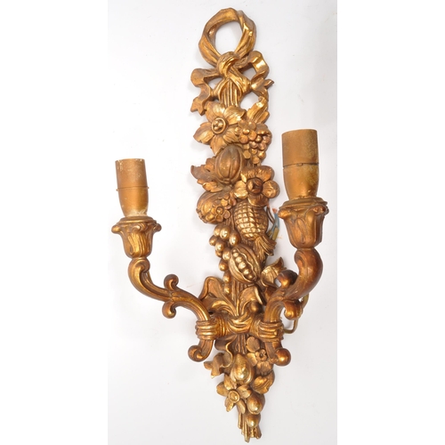 320 - A pair of 19th Century wooden gilt painted wall sconce lights. Each having twin scroll arms against ... 