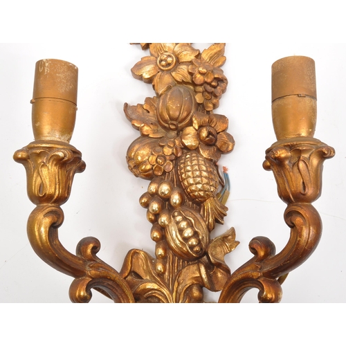 320 - A pair of 19th Century wooden gilt painted wall sconce lights. Each having twin scroll arms against ... 