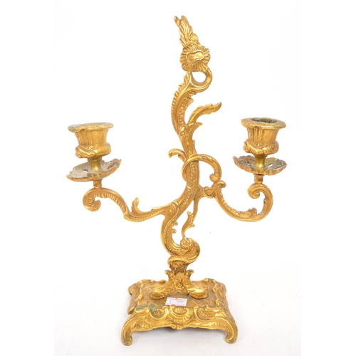 327 - W. T. & S - A early 20th century rococo Italian style gilt candelabra. With scrolled / flame middle ... 