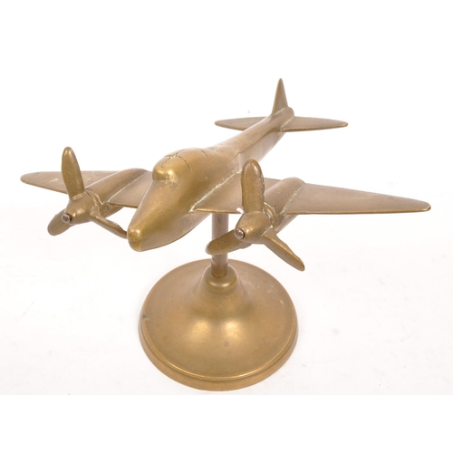 330 - A WWII World War Two hand made brass trench art model Spitfire plane being raised on a circular foot... 