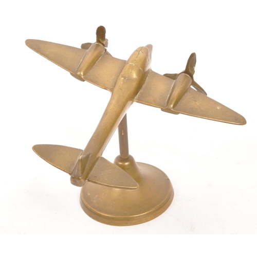 330 - A WWII World War Two hand made brass trench art model Spitfire plane being raised on a circular foot... 