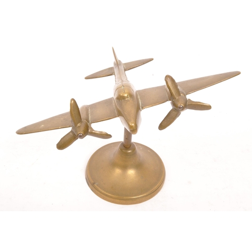 330 - A WWII World War Two hand made brass trench art model Spitfire plane being raised on a circular foot... 