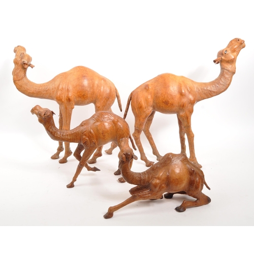 332 - A collection of four papier mache camel figures. Three standing examples with two sitting down. All ... 