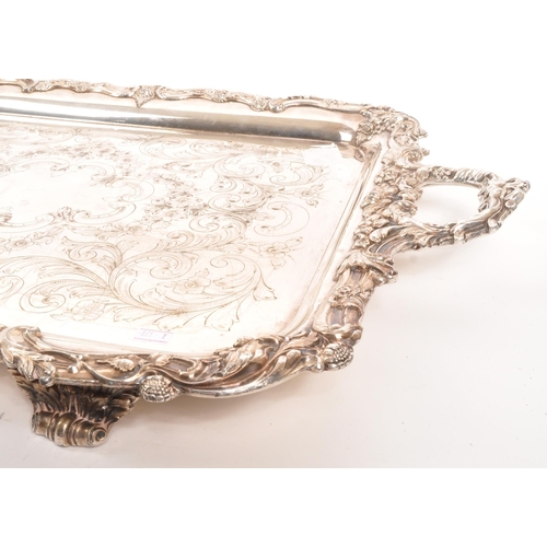 335 - An early 20th century silver plated serving tray. Twin handle, with foliate and floral design to rim... 