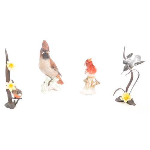 359 - Goebel - A collection of four bird figurines comprising of a china Goebel bird figure, two wrought i... 