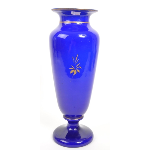 66 - A large early 20th Century cobalt blue opaque vase having hand painted floral spray to front on circ... 