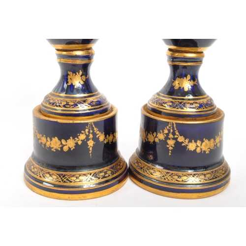 110 - Dresden - A pair of late 19th Century Dresden porcelain twin handled vases having cobalt ground with... 