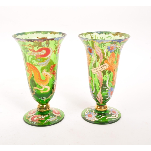 130 - A pair of bohemian 20th Century vintage green glass and enamel vases each having floral animal desig... 