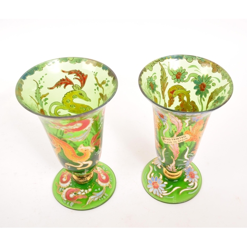 130 - A pair of bohemian 20th Century vintage green glass and enamel vases each having floral animal desig... 