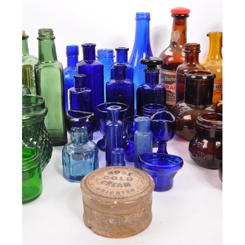 134 - A large collection of early 20th Century and later coloured glass bottles to include medicinal and p... 