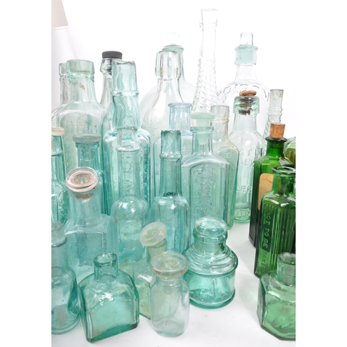 134 - A large collection of early 20th Century and later coloured glass bottles to include medicinal and p... 