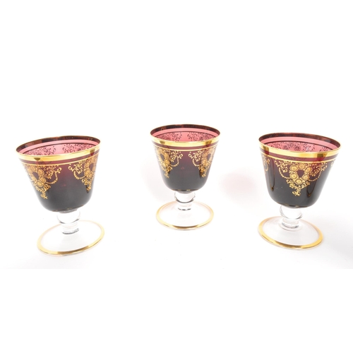 146 - A collection of 20th Century Venetian Amethyst glasses with gilt floral motif and gilt rims. Compris... 