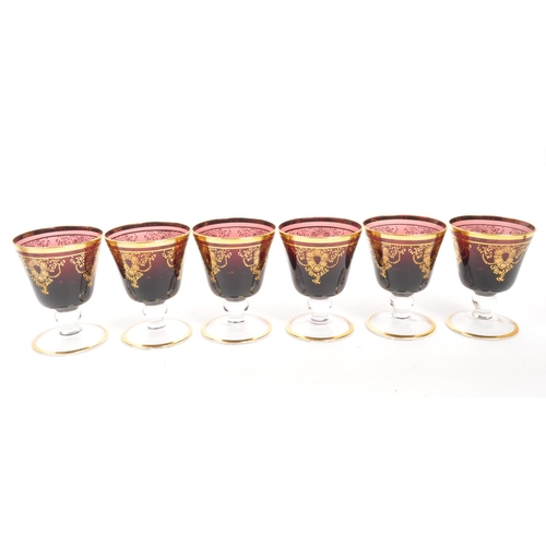 146 - A collection of 20th Century Venetian Amethyst glasses with gilt floral motif and gilt rims. Compris... 