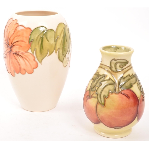 163 - Moorcorft Pottery - Two contemporary ceramic vases. One in the hibiscus pattern in a cream ground wi... 