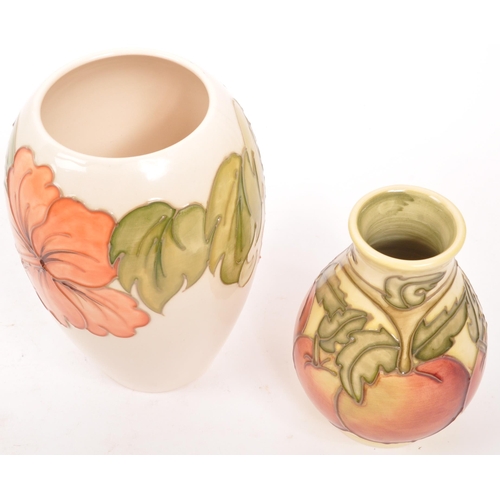 163 - Moorcorft Pottery - Two contemporary ceramic vases. One in the hibiscus pattern in a cream ground wi... 