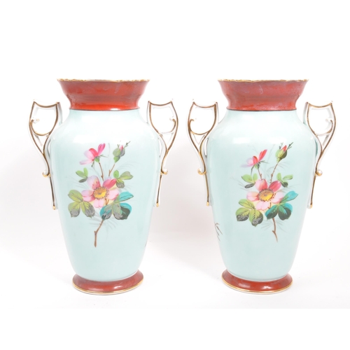 201 - A pair of 20th century twin handled china glasses. Each glass raised on a rounded base, with shaped ... 