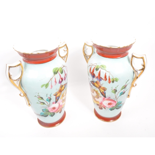 201 - A pair of 20th century twin handled china glasses. Each glass raised on a rounded base, with shaped ... 