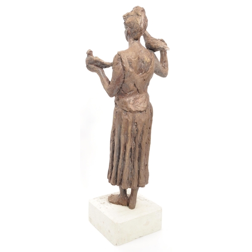 206 - A vintage 20th century sculpture of a woman with a dove on one shoulder, another in her hand. On a w... 