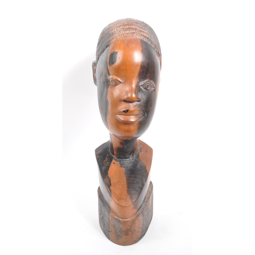 219 - A vintage 20th century African head bust. Depicting an African woman with carved features, raised on... 