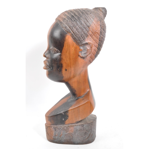 219 - A vintage 20th century African head bust. Depicting an African woman with carved features, raised on... 