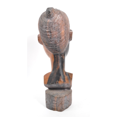 219 - A vintage 20th century African head bust. Depicting an African woman with carved features, raised on... 