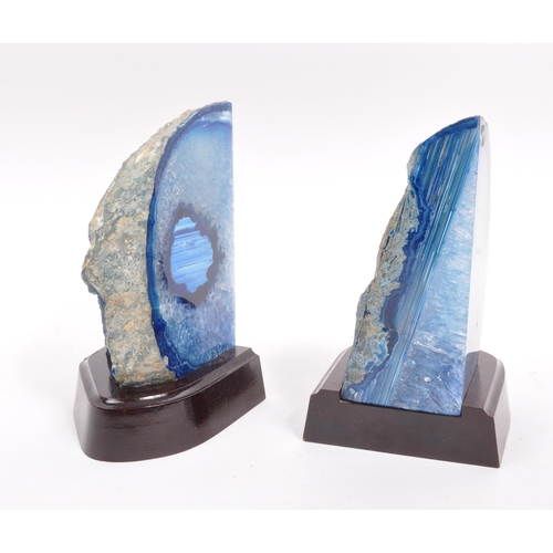 222 - A pair of agate bookends. Each bookend having a shaped mahogany base, with large blue agate geode at... 