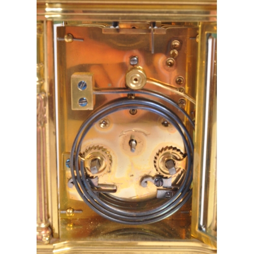 225 - A vintage mid century large brass carriage clock. Having a carry handle to top, a white enamelled fa... 