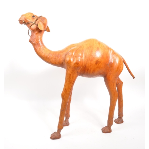 231 - A large 20th Century leather camel figure. The camel standing on all four legs head raised. In orang... 