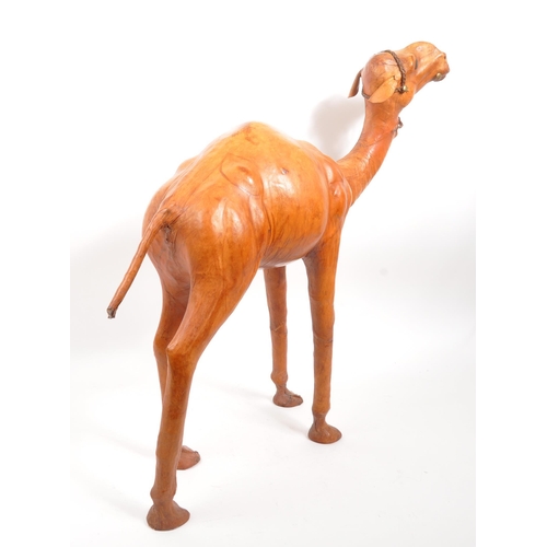 231 - A large 20th Century leather camel figure. The camel standing on all four legs head raised. In orang... 