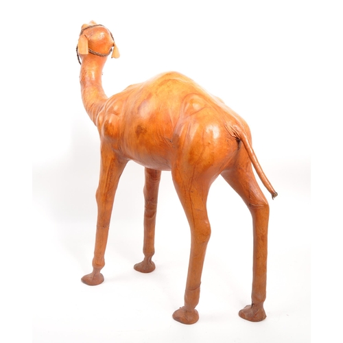 231 - A large 20th Century leather camel figure. The camel standing on all four legs head raised. In orang... 