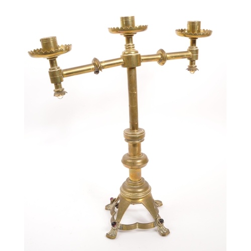 234 - A brass candelabra having glass cabochon detailing to arms and feet. The candelabra having circular ... 