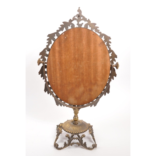 239 - An early 19th Century free standing dressing table mirror. The mirror of ovoid form raised upon scro... 