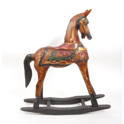 245 - A 20th century folk art painted carved wooden rocking horse. The rocking horse having small proporti... 