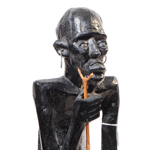 254 - A 20th century African ebonised wood statue figure. The figure in a standing position, raised on a r... 