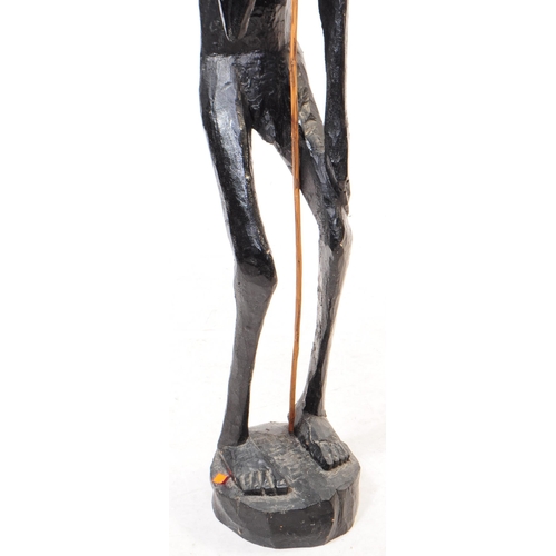 254 - A 20th century African ebonised wood statue figure. The figure in a standing position, raised on a r... 