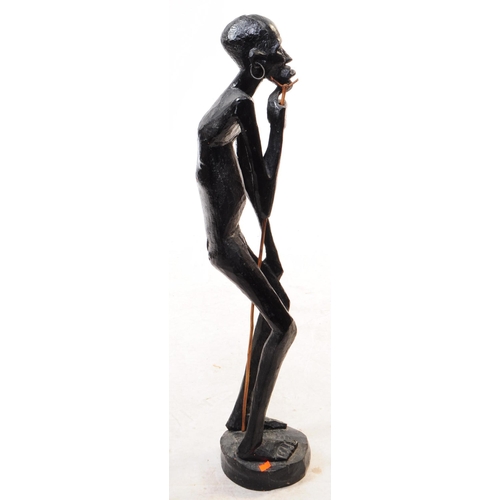 254 - A 20th century African ebonised wood statue figure. The figure in a standing position, raised on a r... 